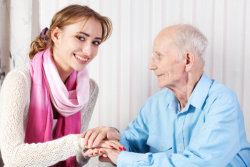 elderly man holding his caregiver's hands